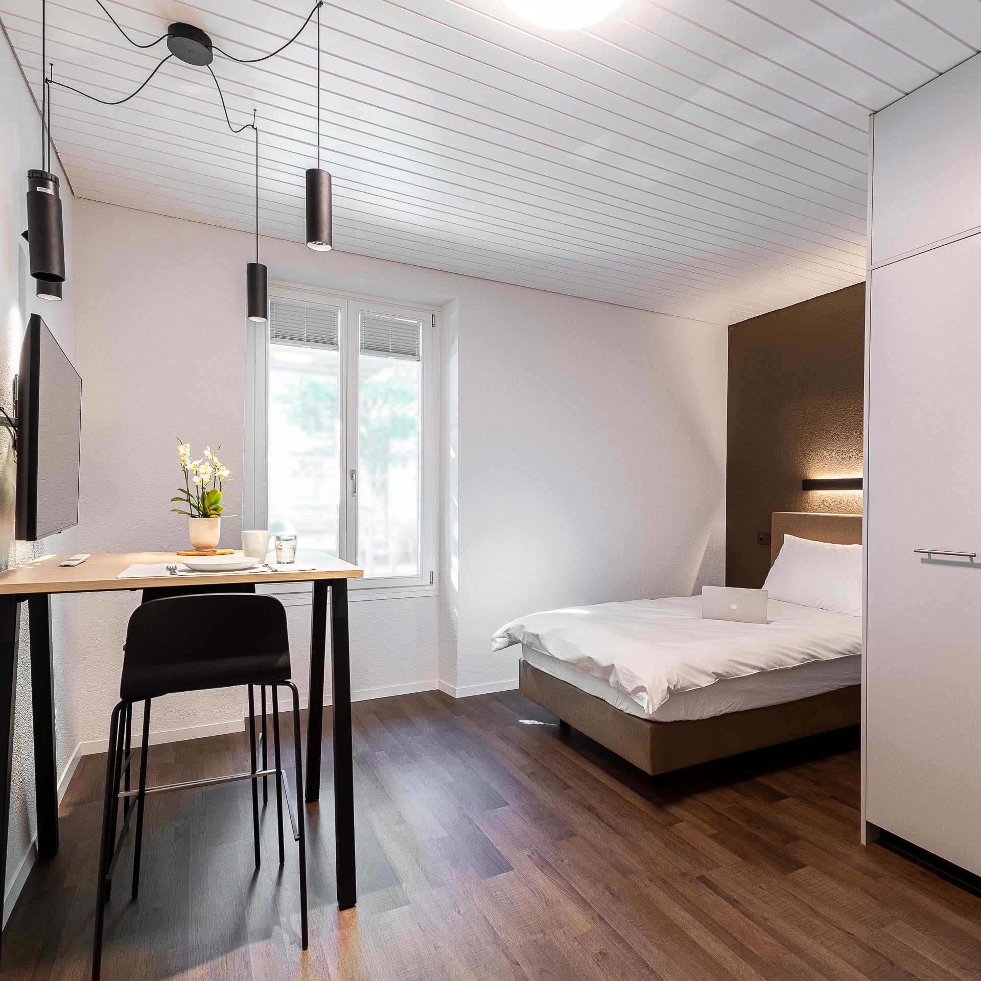 Helle Einzimmerwohnung mit einem Bett und Hochtisch